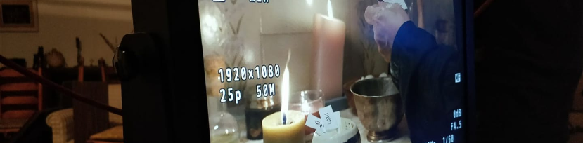 תמונה של מסך מוניטור עם יד של אישה ומסביבה פתקים מיסטים ונרות